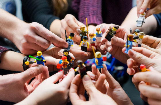 Lots of lego figures being held in many hands